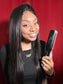 Close-up image of the black and pink titanium flat iron, highlighting its smooth plates and ergonomic handle.