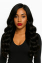 Woman wearing long, loose wave black hair extensions, styled for a sleek, glamorous look