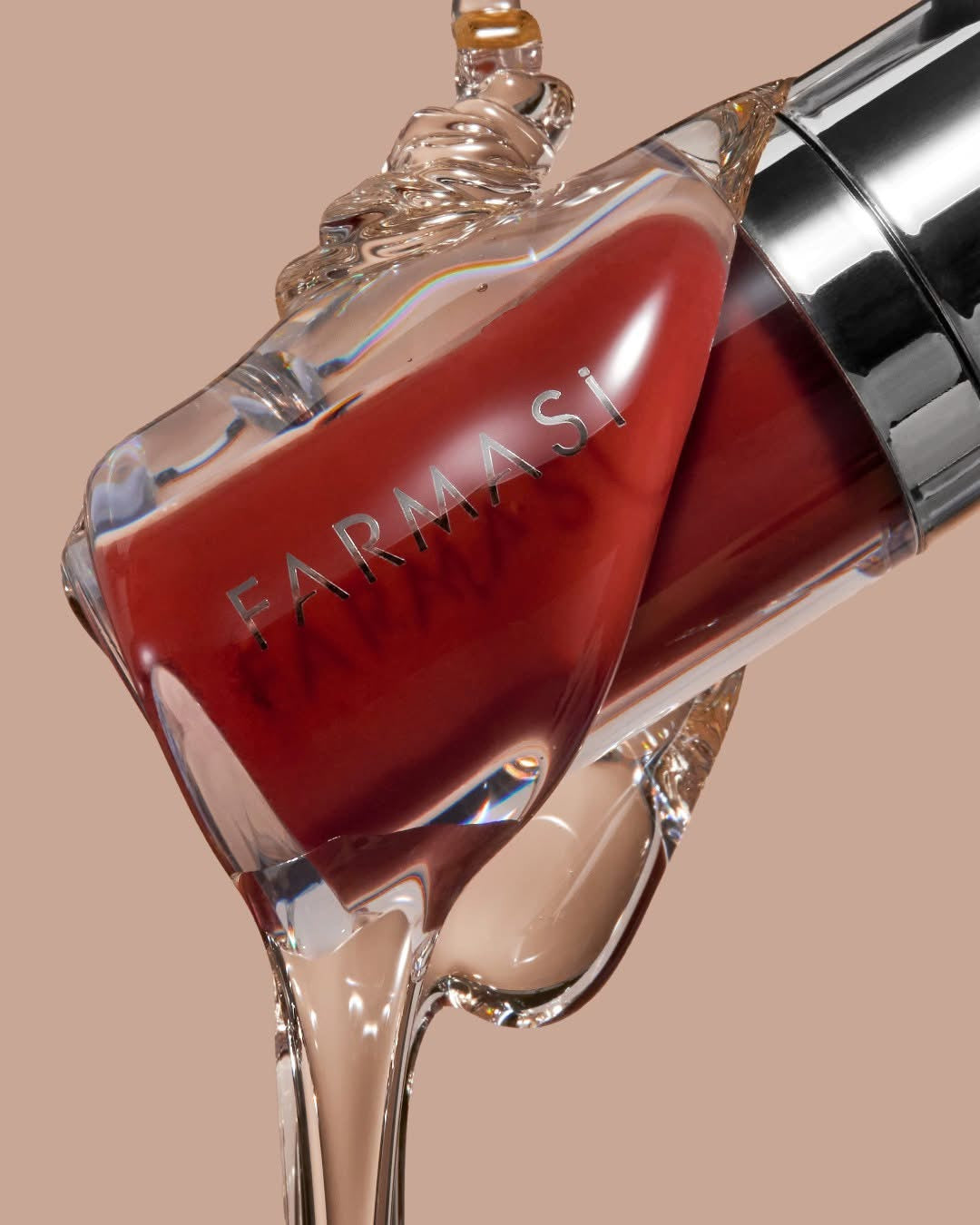 Farmasi liquid lipstick bottle with flowing glossy product on beige background