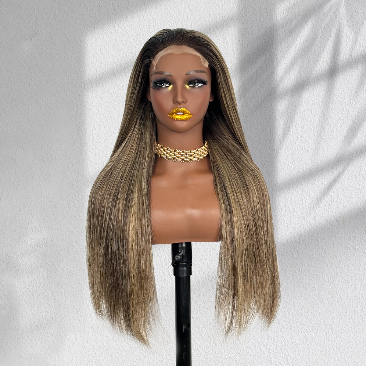 Front view of a straight balayage 5x5 HD lace wig with dark roots and blonde highlights on a mannequin.