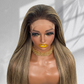 Front close-up of a straight balayage 5x5 HD lace wig showing the lace hairline and blonde face-framing highlights.