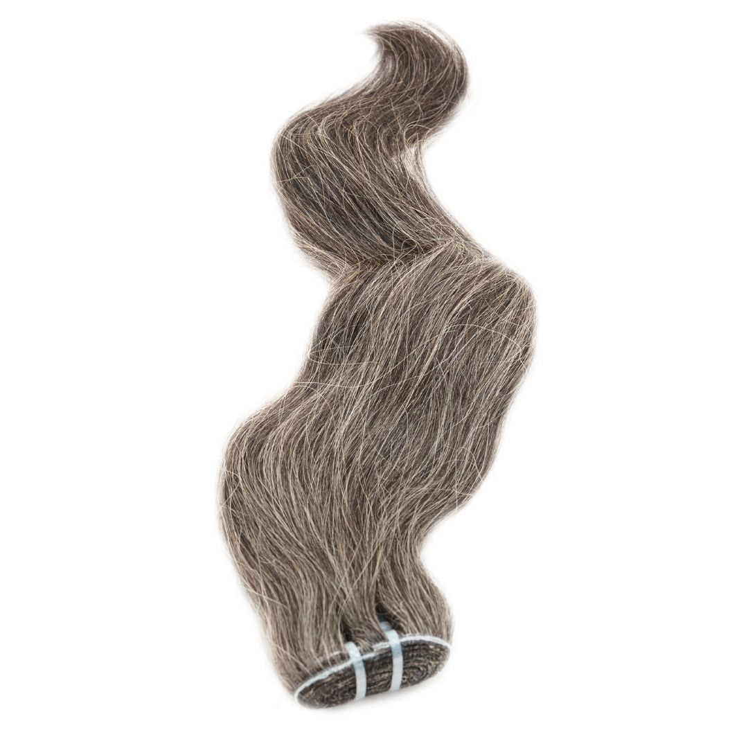Raw Vietnamese Natural Gray Hair Extensions from Nikki Smith Hair Collection, made with 100% raw hair. Available in 14” to 22” lengths, offering a sophisticated gray color and lasting durability with proper care.
